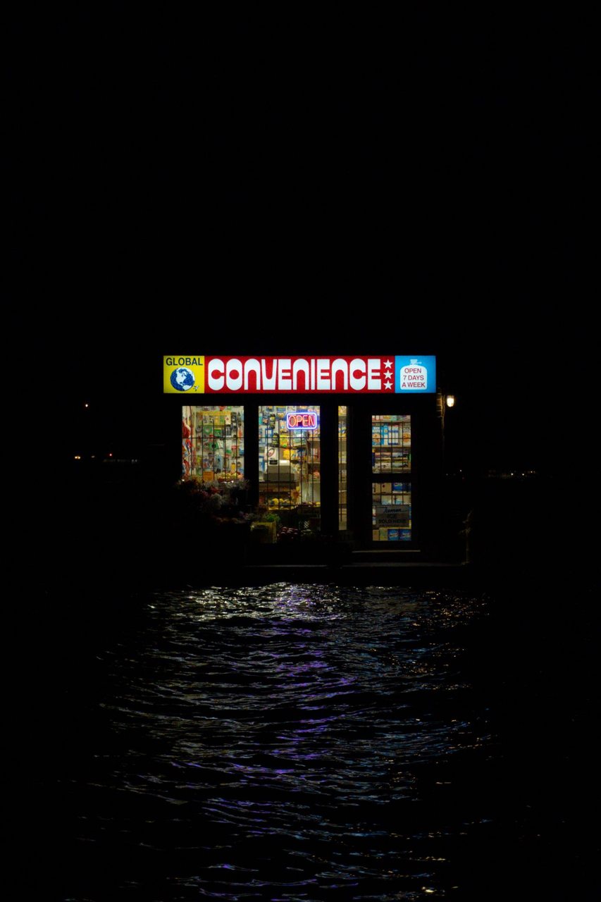 Free Illuminated convenience store reflecting on water at night in Toronto. Stock Photo